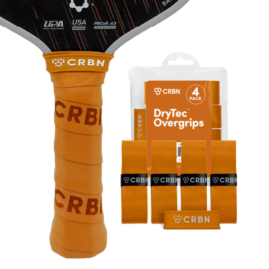 CRBN DryTec Overgrips 4-Pack in Orange, wrapped on a pickleball paddle handle beside the packaging