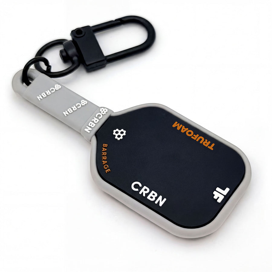 CRBN keychain with black carabiner and gray strap featuring CRBN branding and a gear icon